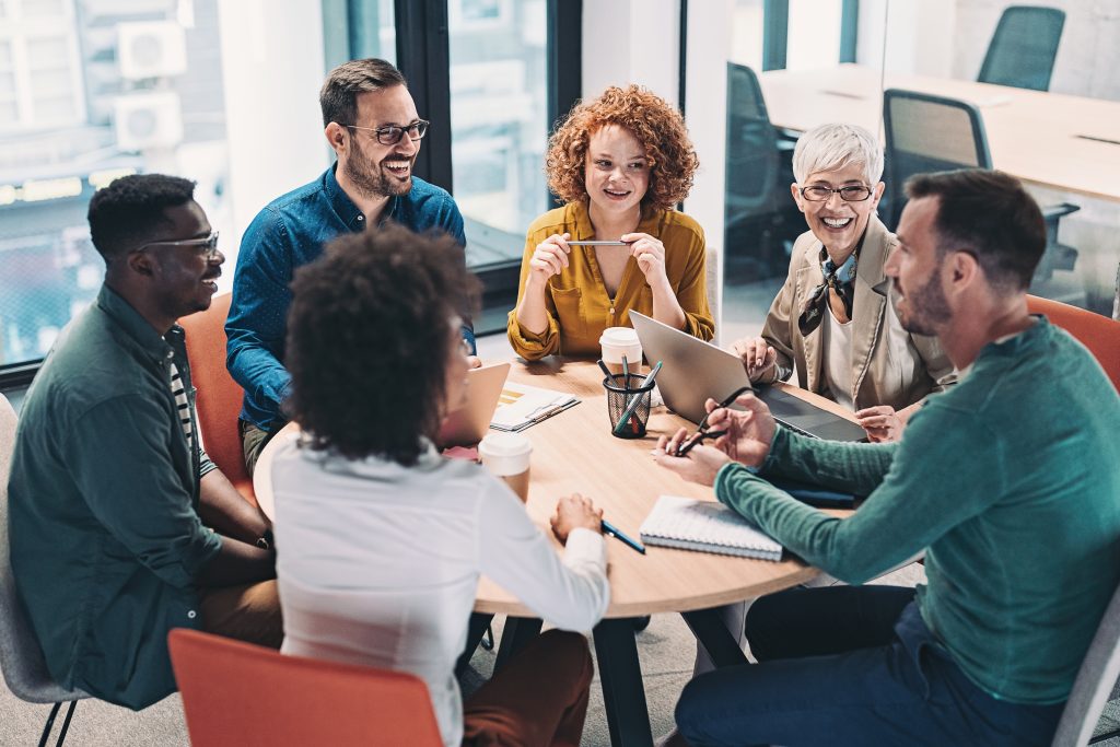 Mixed group of consultantssitting around a table and talking